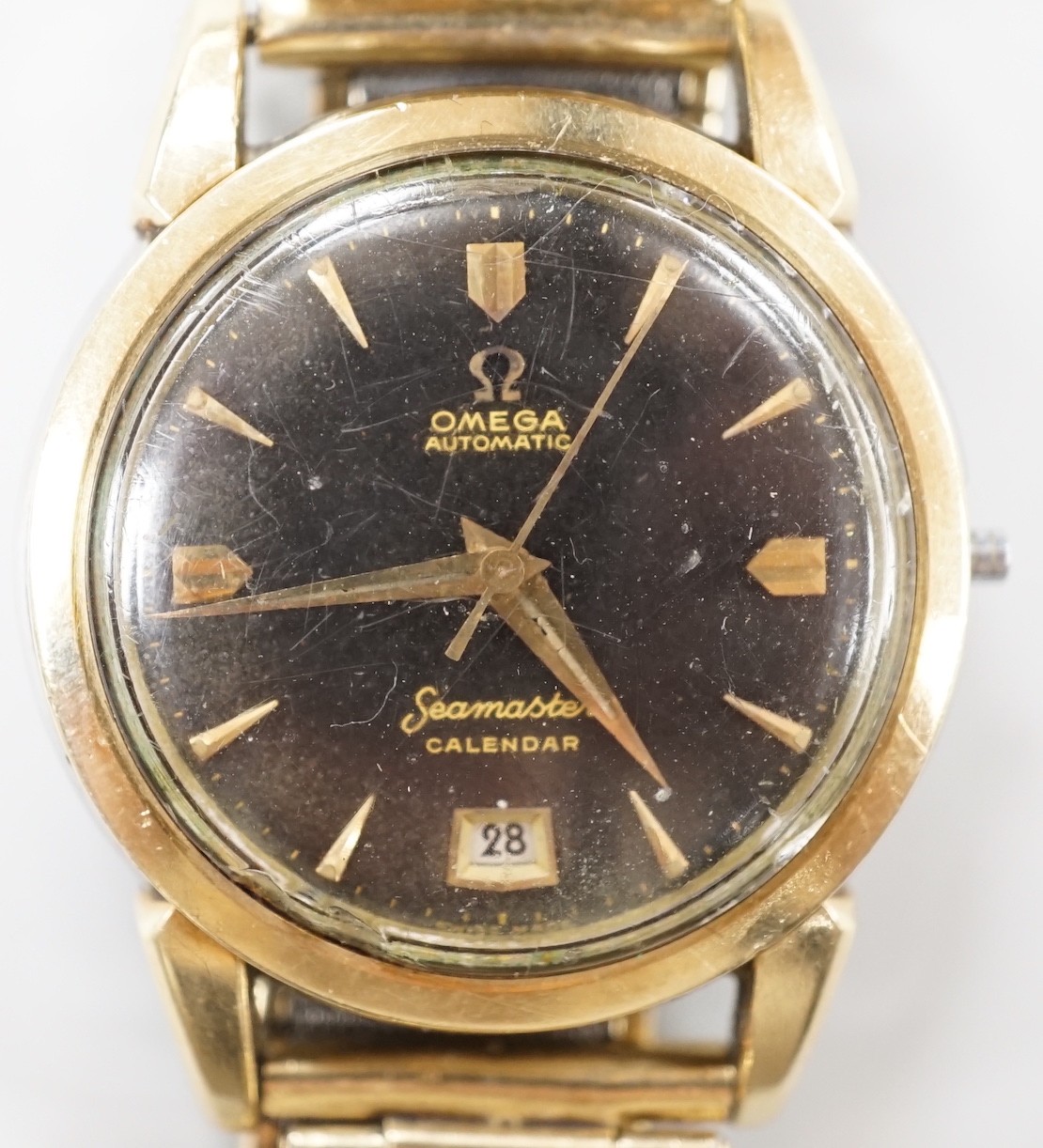 A gentleman's steel and gold plated Omega Seamaster Calendar automatic black dial wrist watch, case diameter 35mm, lacking winding crown, on associated bracelet.